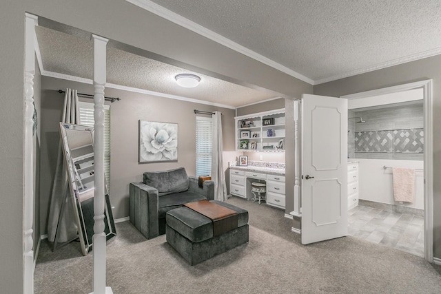 living area featuring a textured ceiling, carpet flooring, ornamental molding, and decorative columns