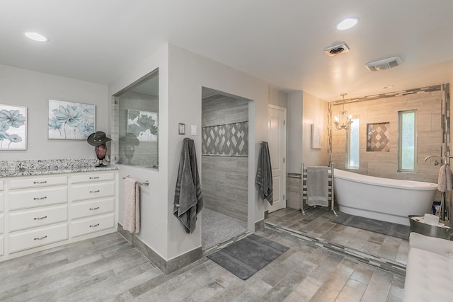 full bathroom featuring wood finished floors, a walk in shower, a chandelier, a soaking tub, and recessed lighting