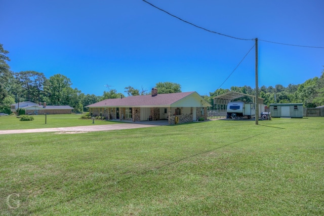 451 Burney St, Coushatta, LA 71019 - view of grassy yard with an outdoor structure, a shed, a detached carport, and concrete driveway