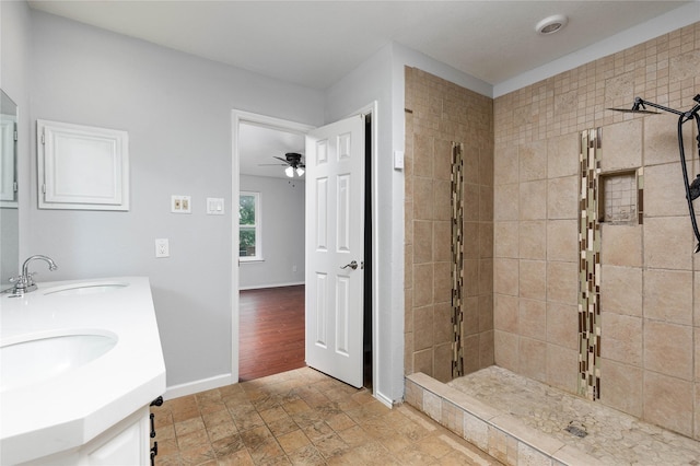 1315 Falcon Dr, Lewisville, TX 75077 - full bathroom featuring a sink, a tile shower, baseboards, and ceiling fan