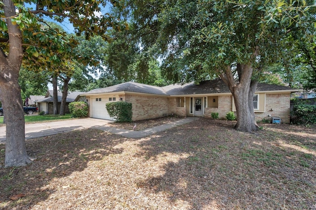 single story home featuring brick siding, a garage, and concrete driveway
