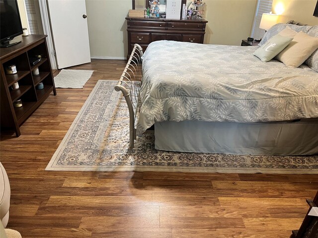 bedroom featuring wood finished floors and baseboards
