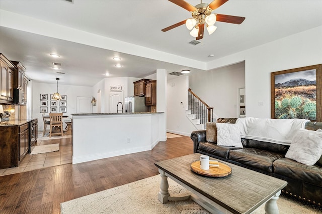 6273 El Capitan St, Fort Worth, TX 76179 - living room with light wood-style floors, ceiling fan, stairs, and baseboards