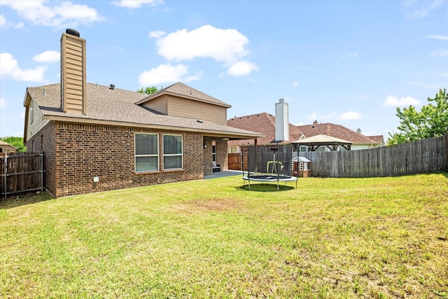 6273 El Capitan St, Fort Worth, TX 76179 - back of house featuring a trampoline, brick siding, a chimney, and a shingled roof