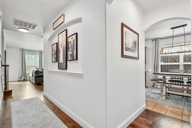 6273 El Capitan St, Fort Worth, TX 76179 - hallway with arched walkways, dark wood-style flooring, and baseboards
