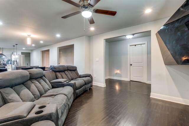 living area featuring baseboards, dark wood-type flooring, a ceiling fan, and recessed lighting