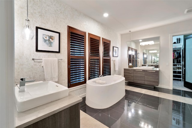 3520 Valmur Ave, Colleyville, TX 76034 - bathroom with a freestanding bath, tile patterned flooring, two vanities, a walk in closet, and baseboards