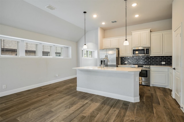 9117 Amistad Ln, Denton, TX 76226 - kitchen with appliances with stainless steel finishes, decorative backsplash, light countertops, an island with sink, and dark wood finished floors