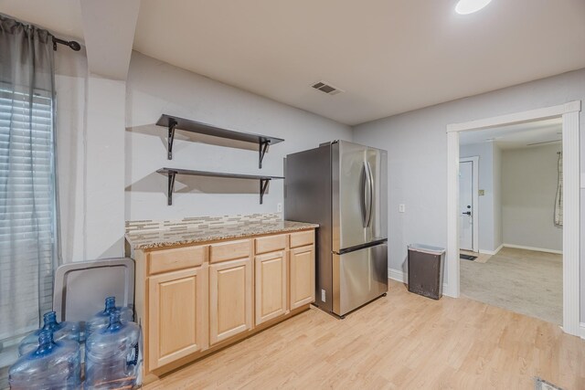 kitchen with open shelves, freestanding refrigerator, light brown cabinetry, light wood finished floors, and baseboards
