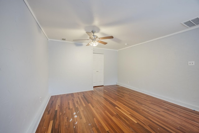 spare room featuring crown molding, a ceiling fan, hardwood / wood-style floors, and baseboards