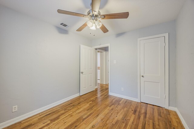 unfurnished bedroom featuring baseboards, light wood-style floors, and a ceiling fan