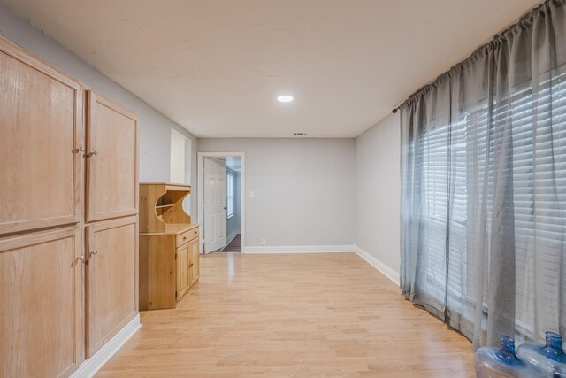 empty room with light wood finished floors, baseboards, and recessed lighting