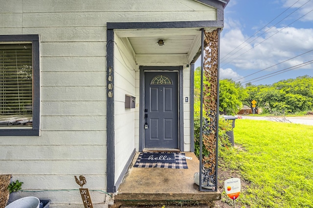 doorway to property with a lawn