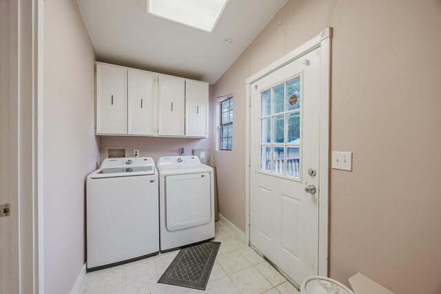 clothes washing area with cabinet space, independent washer and dryer, baseboards, and light tile patterned flooring