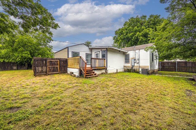 rear view of house with a wooden deck and central air condition unit