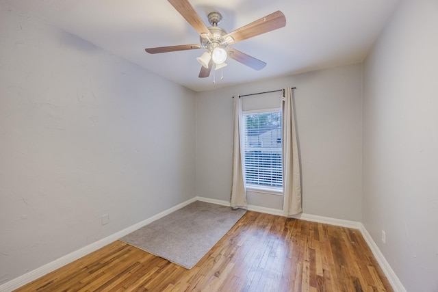 spare room featuring light wood-type flooring, baseboards, and ceiling fan