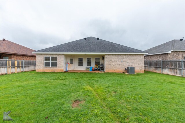 back of property with brick siding, a patio area, central AC unit, and a shingled roof