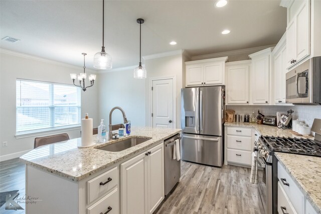 kitchen with appliances with stainless steel finishes, a sink, crown molding, light wood-type flooring, and white cabinetry