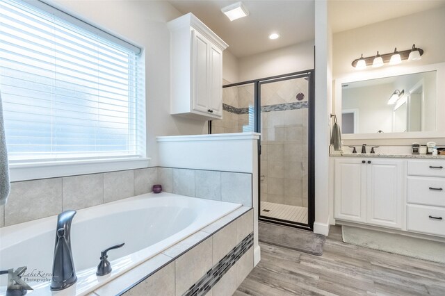 full bathroom with a shower stall, a garden tub, plenty of natural light, and recessed lighting
