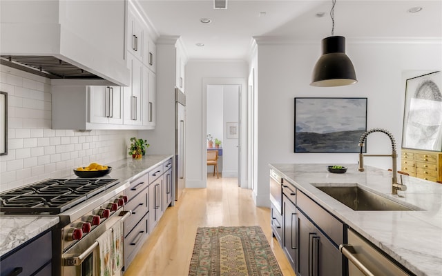 6905 Northridge Dr, Dallas, TX 75214 - kitchen with premium appliances, a sink, premium range hood, crown molding, and white cabinetry
