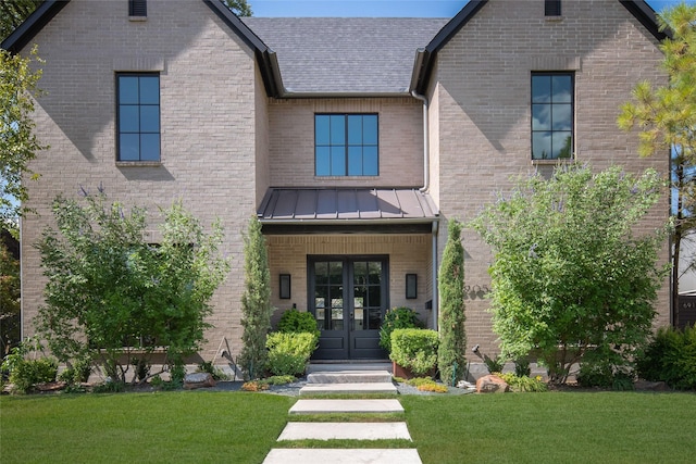6905 Northridge Dr, Dallas, TX 75214 - view of front facade featuring french doors, a front yard, brick siding, and a standing seam roof