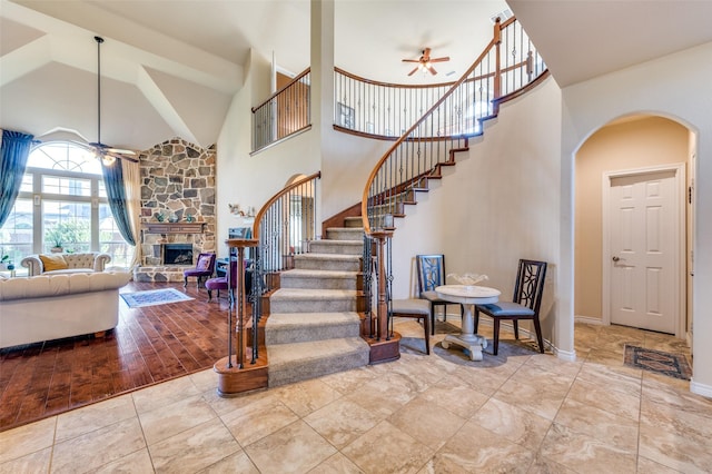 314 Trakehner Trl, Celina, TX 75009 - staircase featuring ceiling fan, high vaulted ceiling, arched walkways, a fireplace, and baseboards