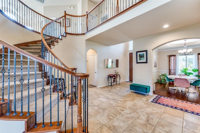 314 Trakehner Trl, Celina, TX 75009 - stairway featuring arched walkways, a chandelier, a high ceiling, and crown molding