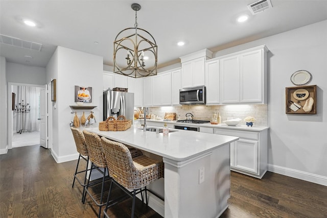 kitchen featuring appliances with stainless steel finishes, a sink, baseboards, backsplash, and light countertops