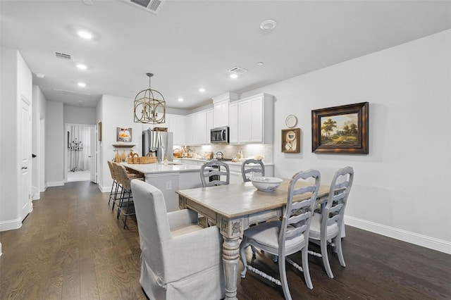 dining room featuring dark wood-style flooring, baseboards, recessed lighting, and a chandelier