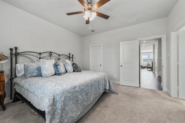 carpeted bedroom featuring baseboards and a ceiling fan