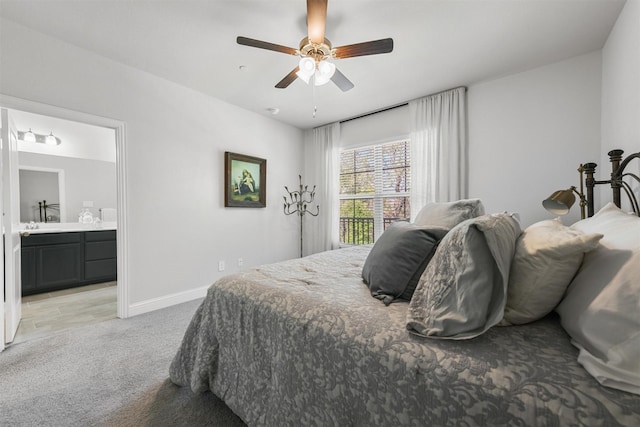 bedroom with light carpet, baseboards, ensuite bath, and ceiling fan