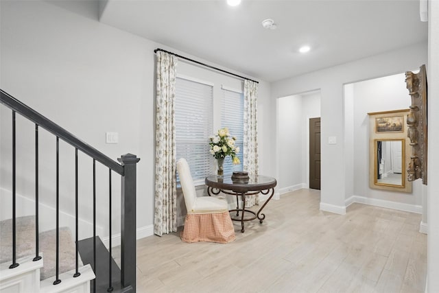 sitting room featuring baseboards, light wood finished floors, stairs, and recessed lighting