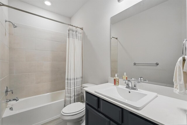 bathroom featuring toilet, shower / tub combo with curtain, vanity, and recessed lighting