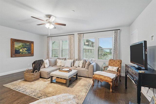 living area with a ceiling fan, wood finished floors, and baseboards