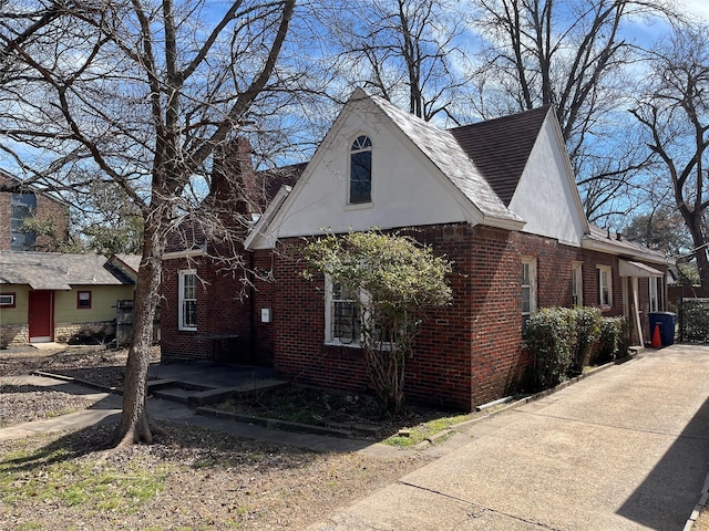 218 E 5th St, Dallas, TX 75203 - view of side of property featuring brick siding, a chimney, and stucco siding