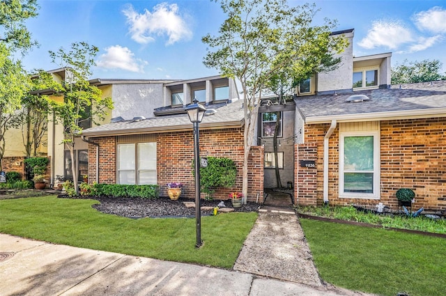9826 Bent Branch Ln, Dallas, TX 75243 - view of front facade featuring a front lawn, brick siding, a shingled roof, and stucco siding