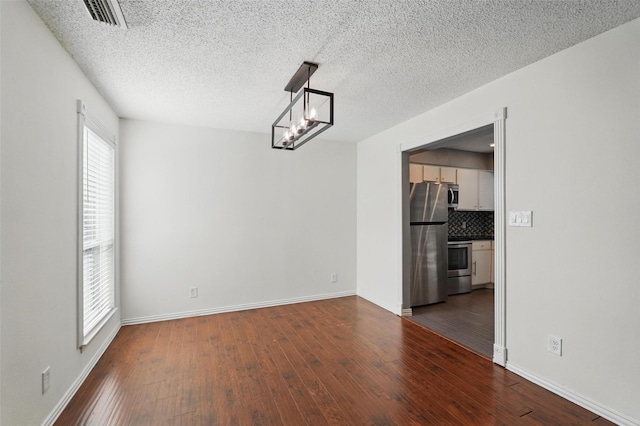 9826 Bent Branch Ln, Dallas, TX 75243 - unfurnished living room featuring a textured ceiling, stairs, wood finished floors, a chandelier, and baseboards