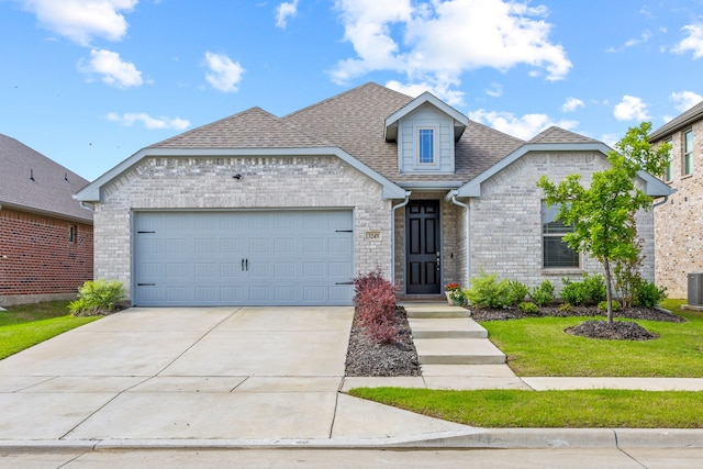 3249 Glorioso Dr, Royse City, TX 75189 - view of front of house featuring a shingled roof, concrete driveway, brick siding, an attached garage, and cooling unit