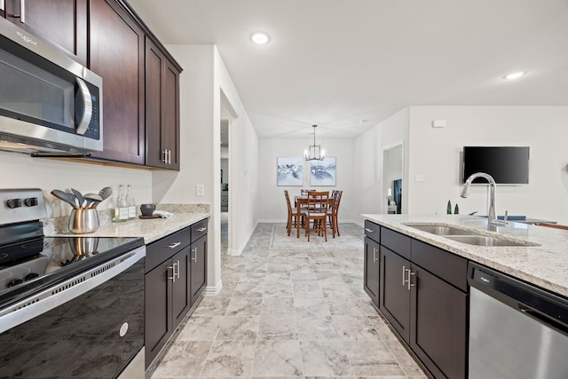 3249 Glorioso Dr, Royse City, TX 75189 - kitchen featuring stainless steel appliances, a sink, dark brown cabinetry, light stone countertops, and a chandelier