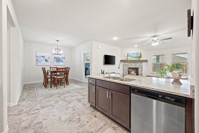3249 Glorioso Dr, Royse City, TX 75189 - kitchen with dishwasher, a sink, ceiling fan, a glass covered fireplace, and baseboards