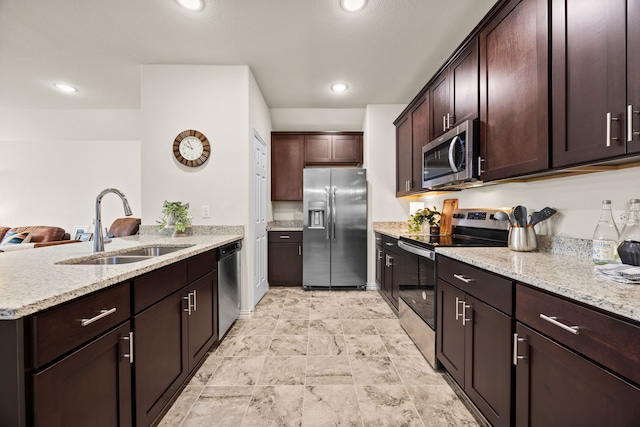 3249 Glorioso Dr, Royse City, TX 75189 - kitchen featuring stainless steel appliances, a sink, a peninsula, light stone countertops, and recessed lighting