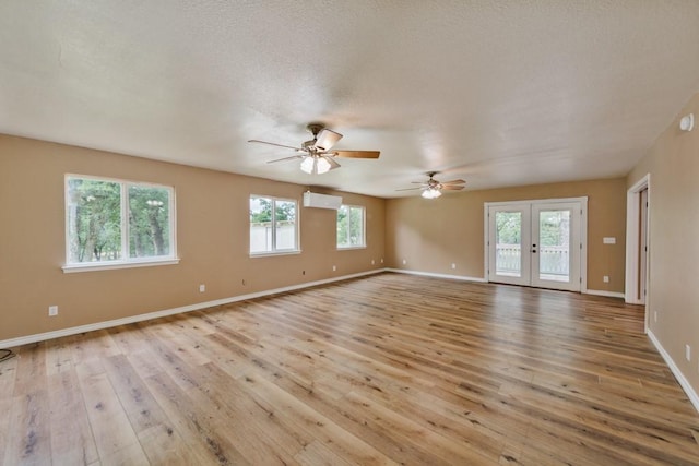 1941 State Highway 59 S, Bowie, TX 76230 - empty room with an AC wall unit, light wood finished floors, french doors, a ceiling fan, and baseboards