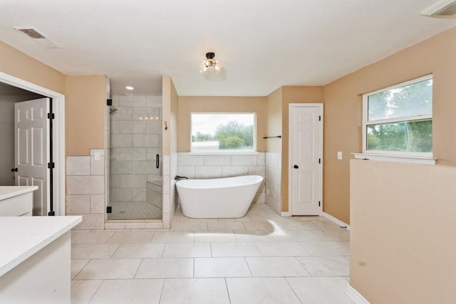 1941 State Highway 59 S, Bowie, TX 76230 - bathroom featuring a stall shower, vanity, a freestanding tub, baseboards, and tile walls