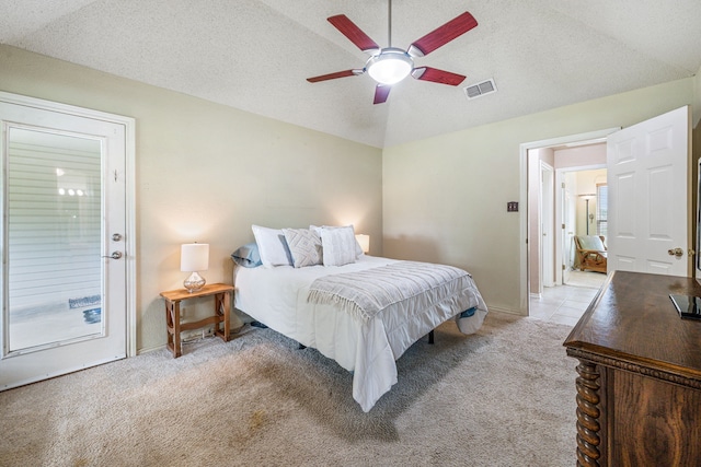 bedroom with vaulted ceiling, light colored carpet, ceiling fan, and a textured ceiling