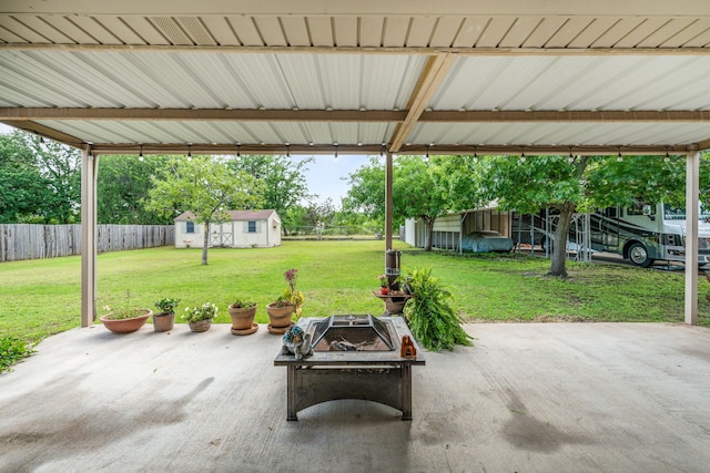 view of patio featuring an outbuilding and a fire pit