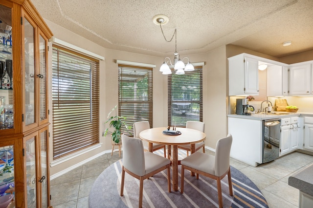 dining space with light tile patterned floors, a chandelier, a textured ceiling, and baseboards