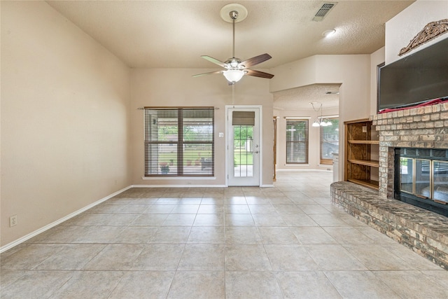 unfurnished living room featuring a ceiling fan, a fireplace, baseboards, a textured ceiling, and light tile patterned floors