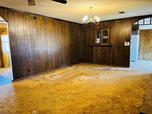3122 Frances Dr, Denison, TX 75020 - unfurnished dining area with a textured ceiling, a chandelier, wood walls, and light carpet