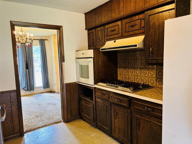3122 Frances Dr, Denison, TX 75020 - kitchen featuring white appliances, extractor fan, a chandelier, light floors, and a wainscoted wall