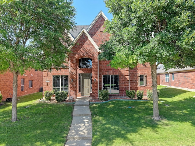 traditional-style home featuring a front yard and brick siding